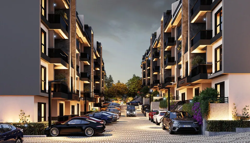 Serenity Town — akşam saatlerinde aydınlatılmış blok cepheleri ve site içi yol